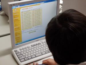 パソコンを使って米に関する知識を調べる学生
