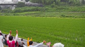 手を振り続ける住民たち